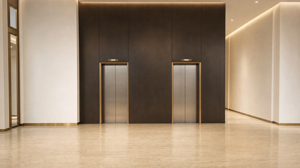 The front lift bank, two lifts set into a dark stone wall between pale plaster returns